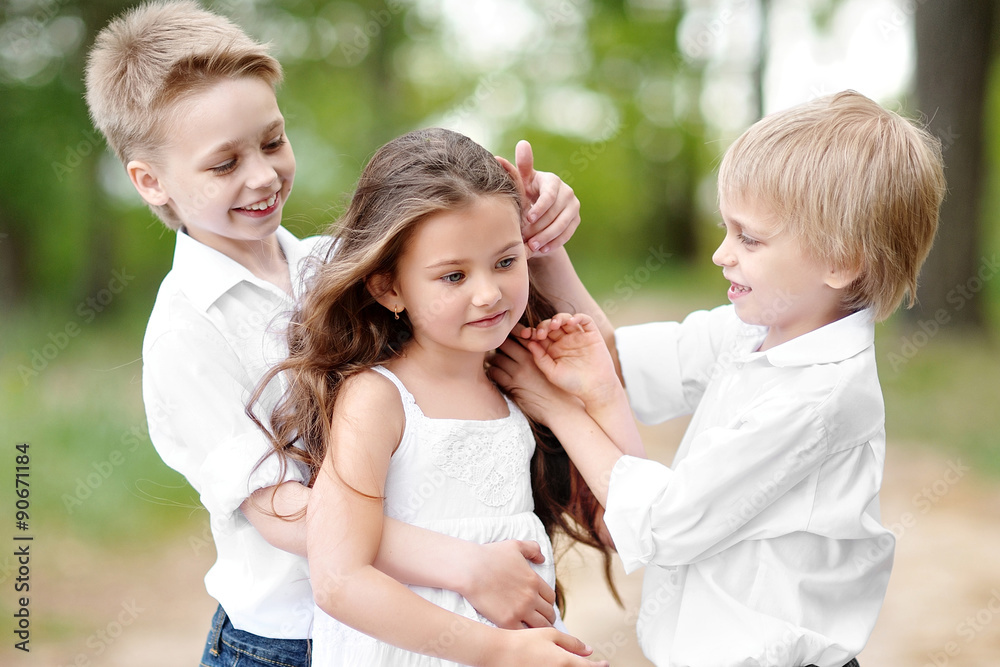 Fototapeta premium three children playing on meadow in summer