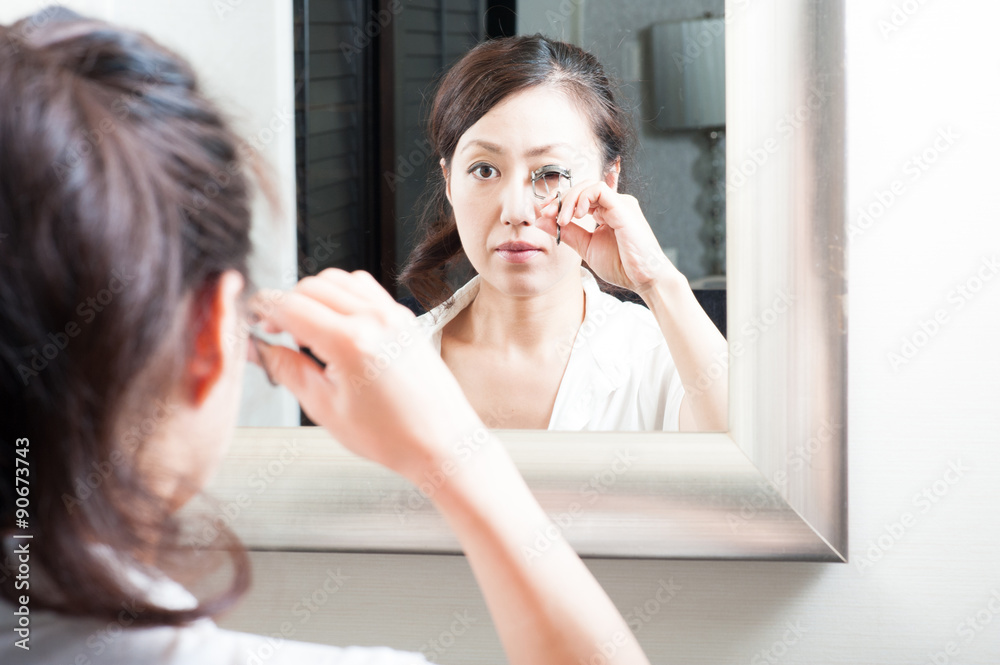 鏡を見て化粧をしている日本人女性 鏡を見て化粧をしている日本人女性