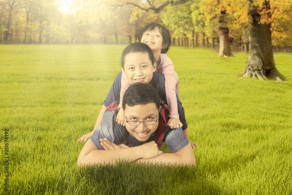 Dad playing with his children at the autumn park Dad playing with his children at the autumn park