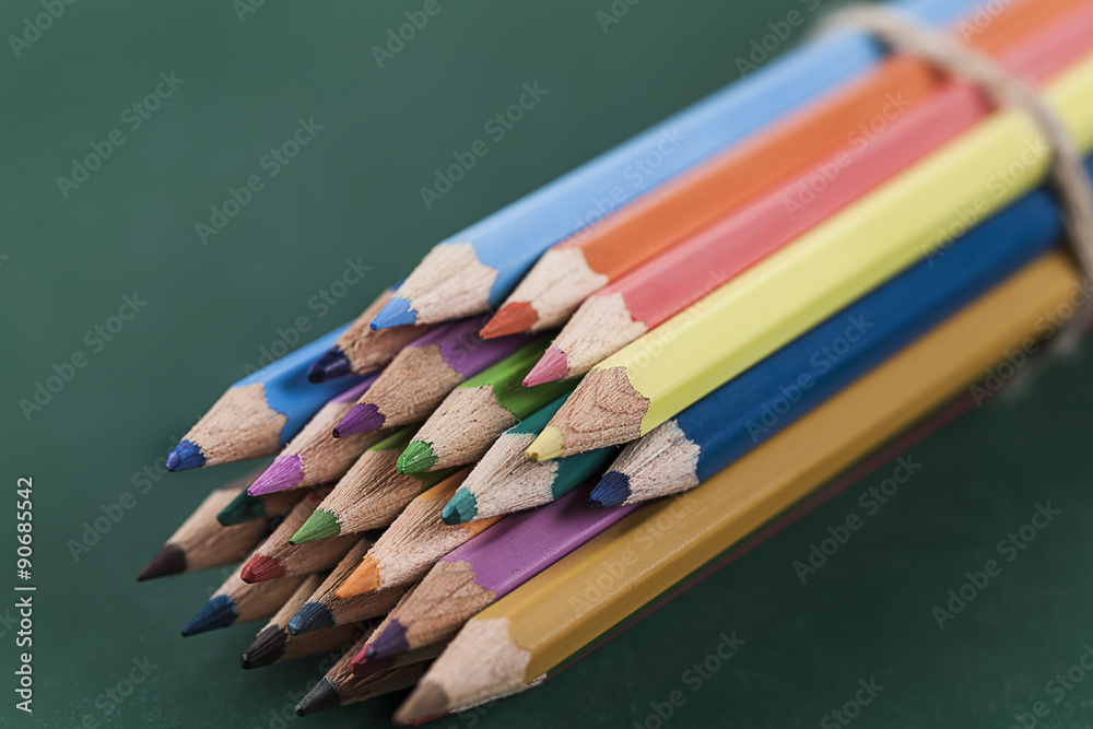 Colored pencils on green chalkboard Colored pencils on green chalkboard