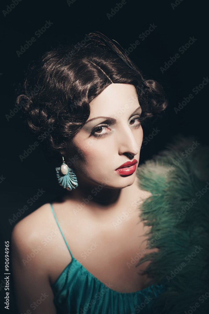 Glamour retro 1920s young woman holding a fan. Against black bac Glamour retro 1920s young woman holding a fan. Against black bac