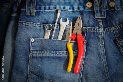 Several tools on a denim workers pocket. photo