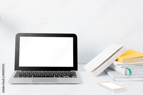 laptop , smartphone, and stack of books at office desk