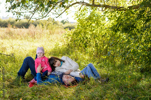 Family resting the meadow in autumn