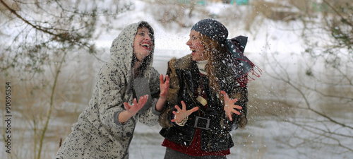 Two funny girls on the background of winter nature