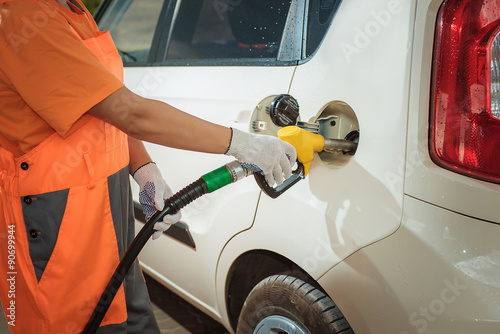 girl pumping diesel in to the tank. car fill with gaon pump. soline at a gas station. Gas stati photo