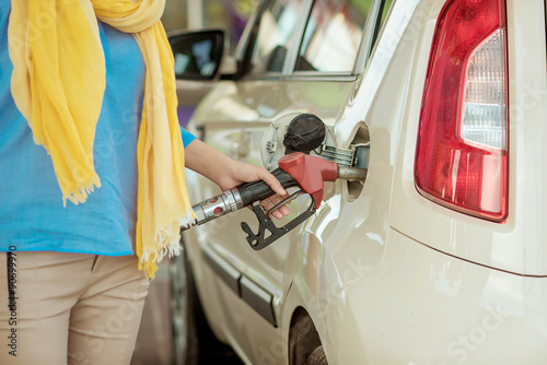 girl pumping diesel in to the tank. car fill with gaon pump. soline at a gas station. Gas stati photo