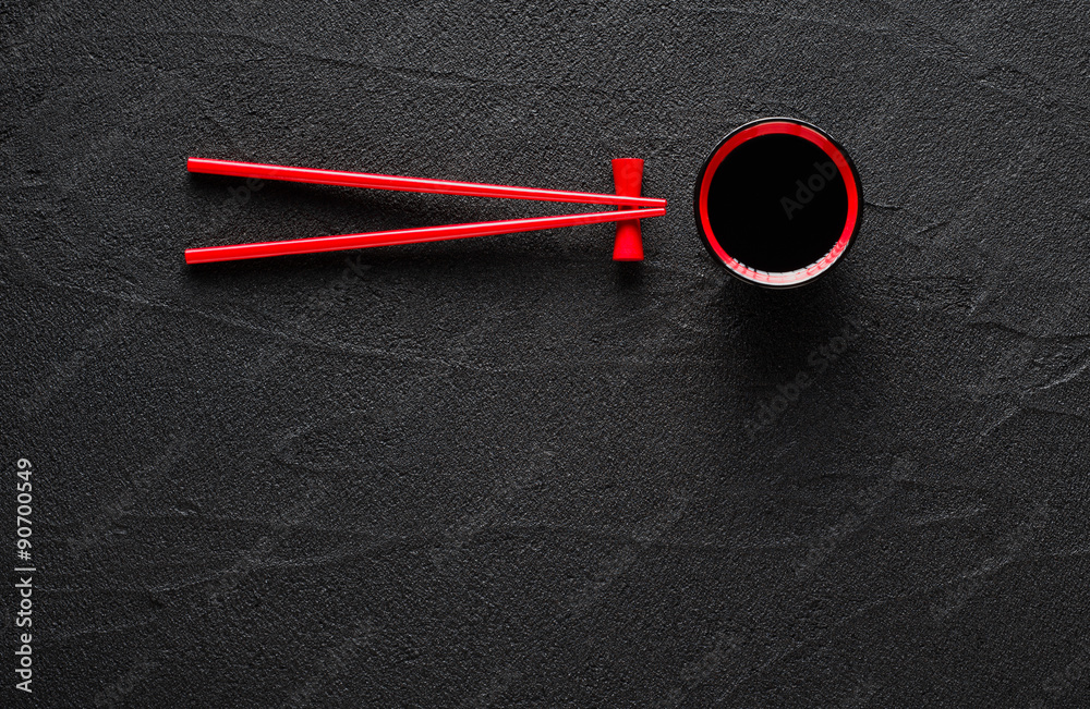 Chopsticks and bowl with soy sauce on black stone background Chopsticks and bowl with soy sauce on black stone background