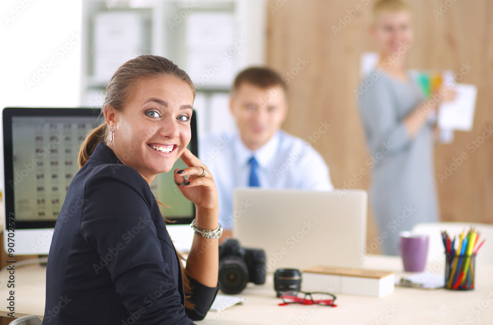 Female photographer sitting on the desk with laptop Female photographer sitting on the desk with laptop