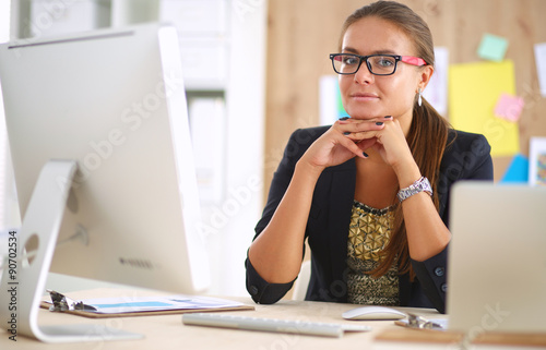 Fashion designers working in studio sitting on the desk