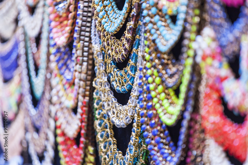 Bright costume jewelry of various colors on a show-window of shop