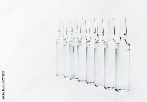Break-seal glass ampoule set with liquid medicine on white background.