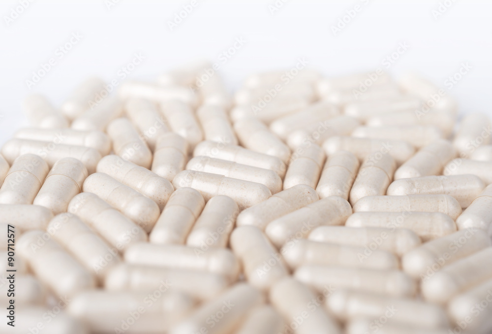 Spilled white capsules on the white background Spilled white capsules on the white background