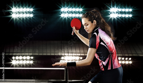 Beauty sporty girl playing table tennis on black background