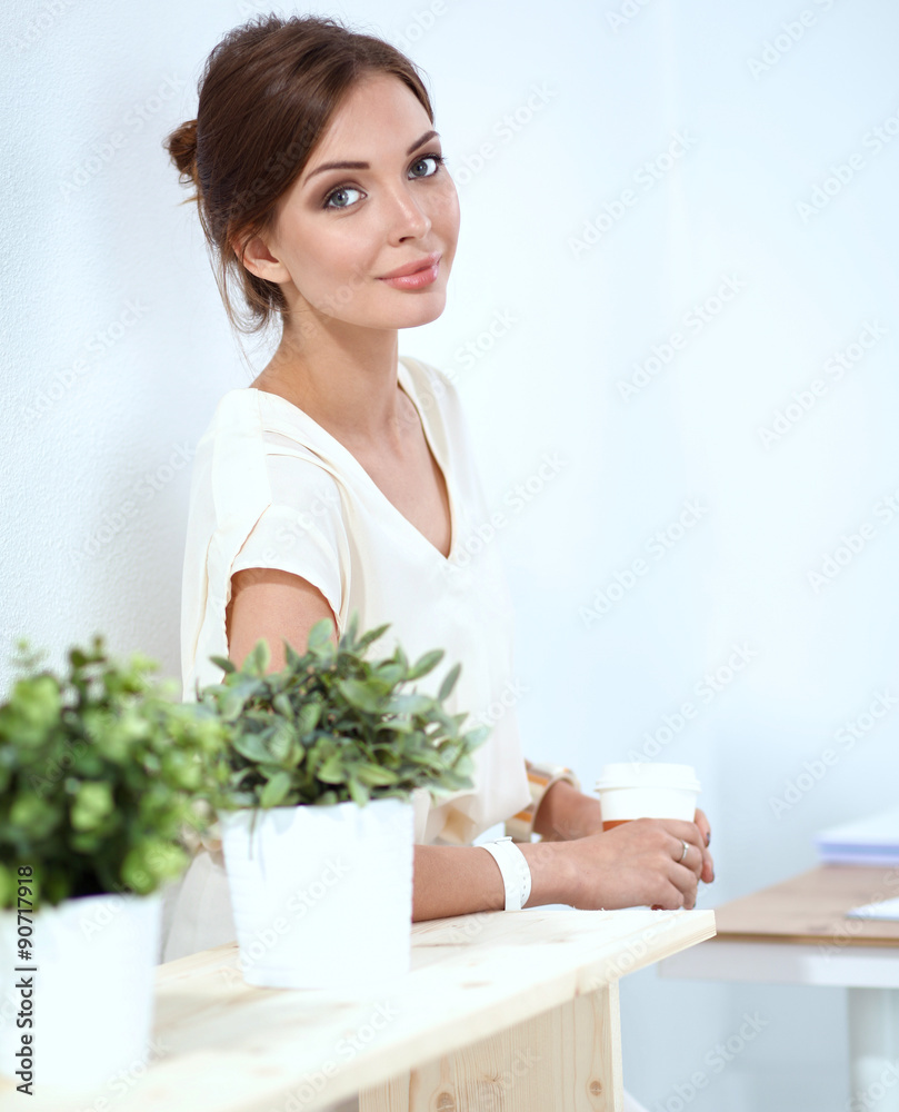 Attractive businesswoman standing near wall in office Attractive businesswoman standing near wall in office