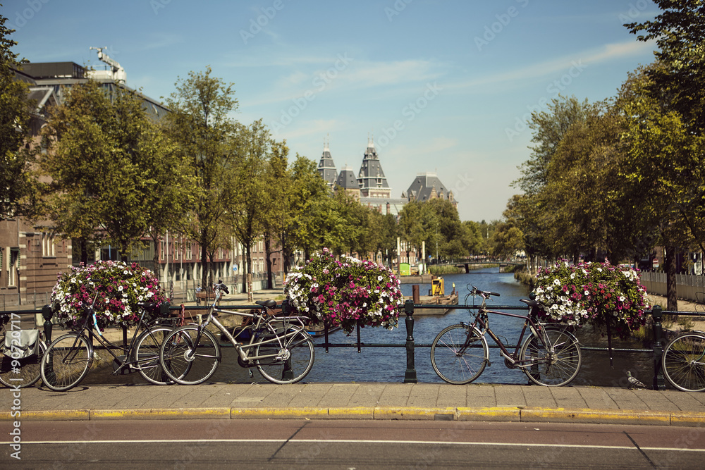 Vista de ponte em Amsterdão com bicicletas em primeiro plano.
