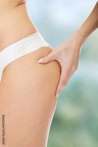 Slim woman pinching her buttocks.