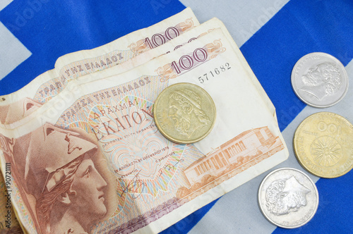 Greek old currency drachma banknotes on the Greek flag photo