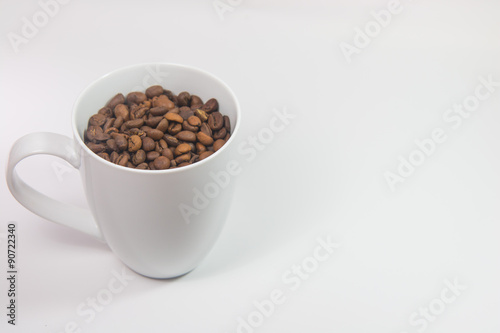 Coffee beans in a cup on white background