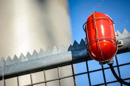 Rote Warnleuchte an Sicherheitszaun