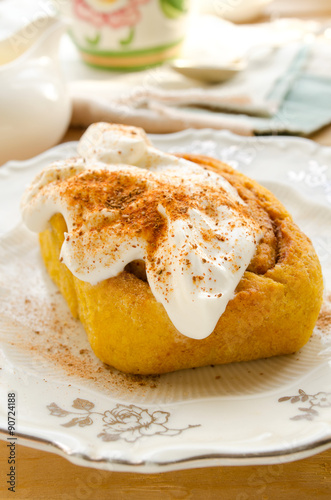 Homemade pumpkin cinnamon rolls with spices and sweet cream