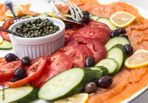 Obraz na płótnie Deli platter with smoked salmon, tomatoes, cucumbers, olives and capers