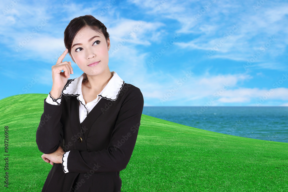 Business woman thinking with green grass field and sea Business woman thinking with green grass field and sea