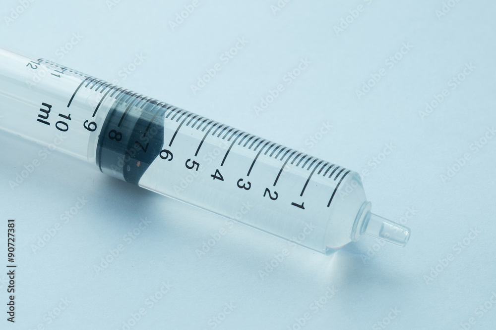 syringe with clear liquid on light background syringe with clear liquid on light background