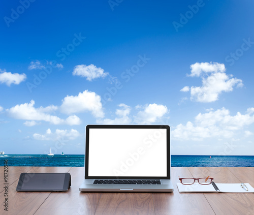 Blank screen laptop computer with sea background