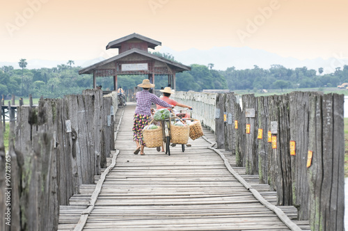 Two women across U Bein bridge after going market