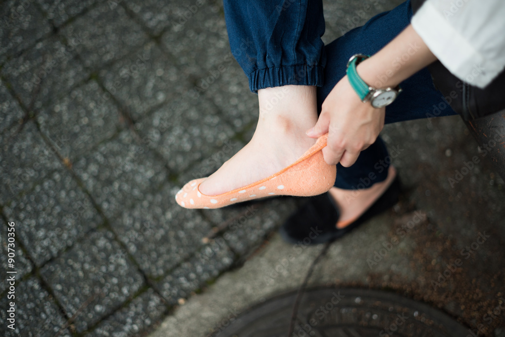 靴下を履きなおす若い女性 靴下を履きなおす若い女性