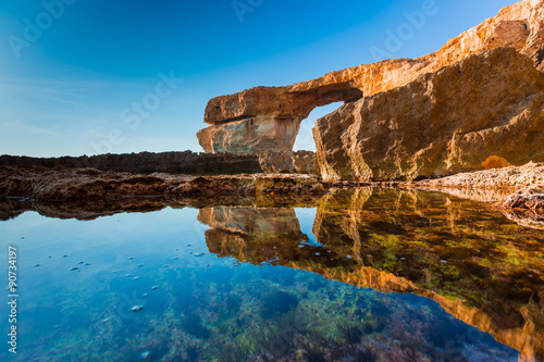 Azure Window, famous stone arch on Gozo island with reflection,