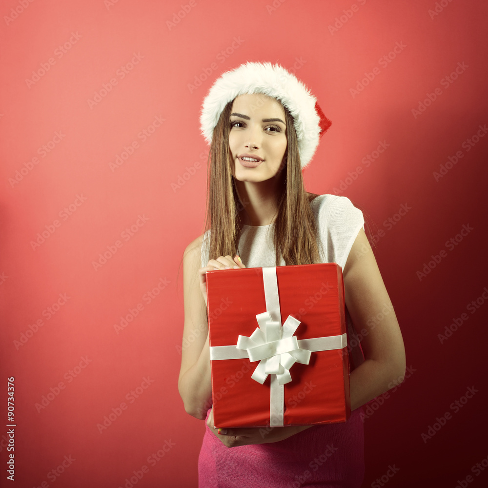 Young woman in santa helper hat with gift box and shopping bag o Young woman in santa helper hat with gift box and shopping bag o