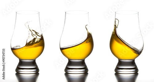 Yellow liquor in whiskey glass splash