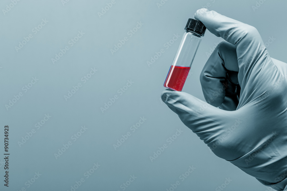 Vial in hand with a glove Vial in hand with a glove