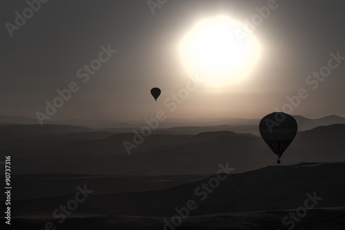 Balloons in cappadocia over mointains and rocks