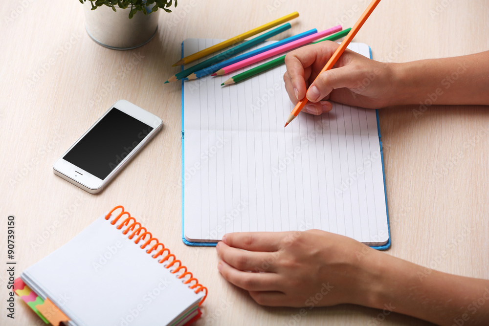 Woman write on notebook on workplace close up Woman write on notebook on workplace close up