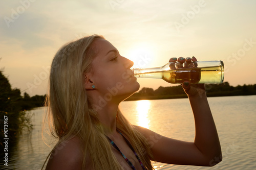 junge Frau mit Flasche im See,  Brandenburg, Deutschland
