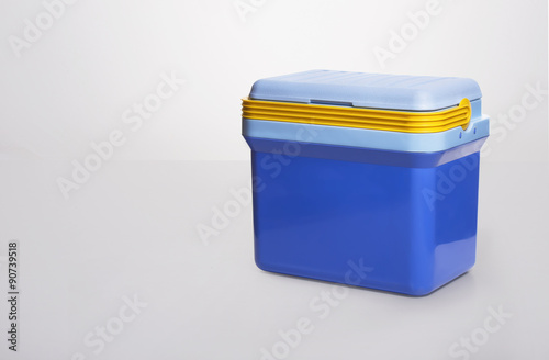 beautiful  blue cooler with a. yelllow handle on . white