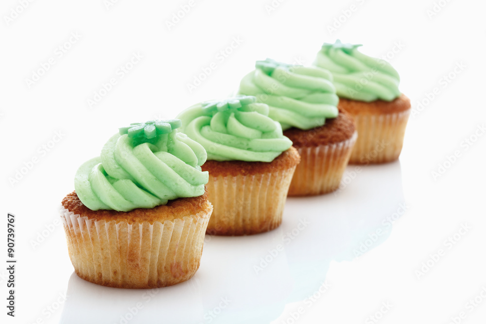 Nahaufnahme von Buttercreme Waldmeister Cupcake vor weißem Hint Nahaufnahme von Buttercreme Waldmeister Cupcake vor weißem Hint
