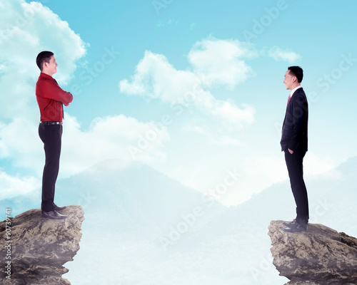 Two business man standing on the top of the mountain