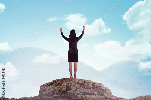 Asian business woman standing on the top of the mountain
