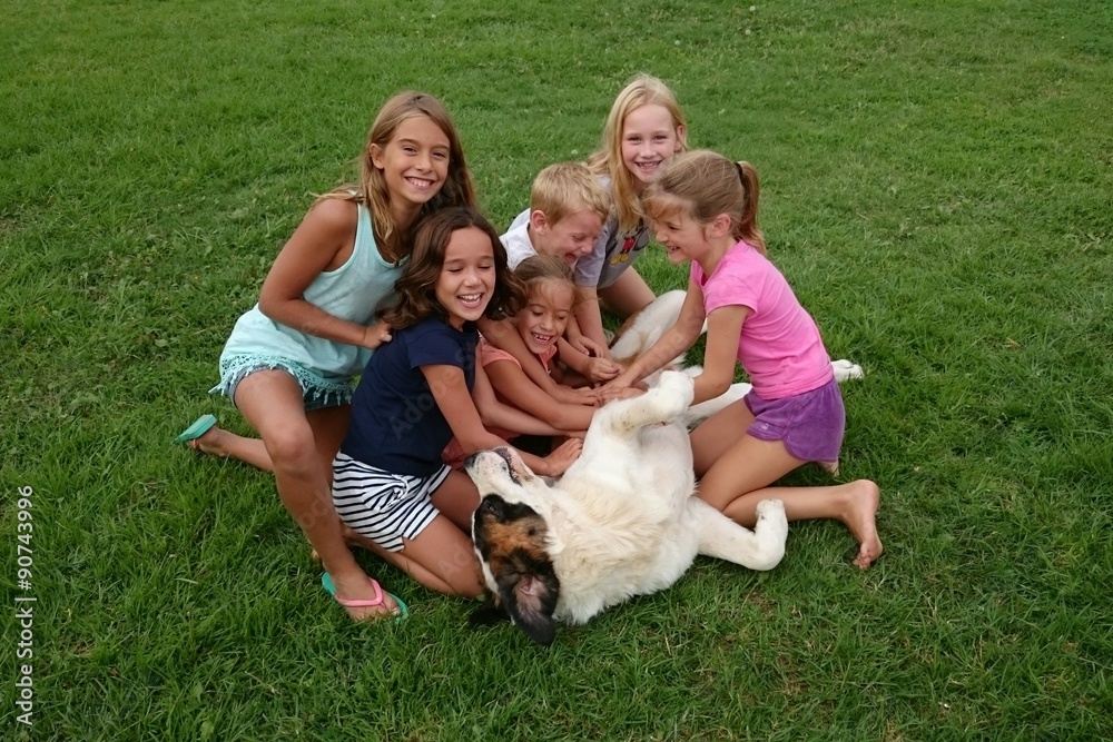 Niños haciéndole cosquillas a perro