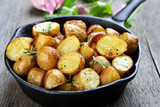 Potato fried in pan on rustic table