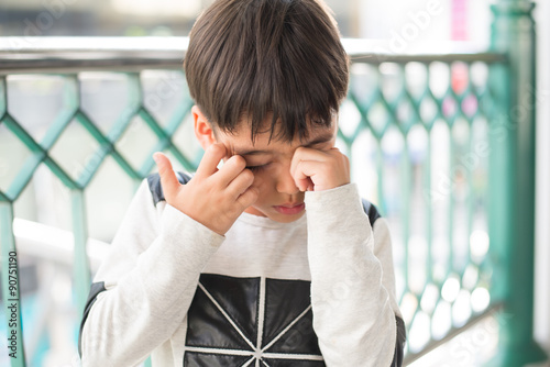 Little boy ichy his eyes with crying outdoor photo