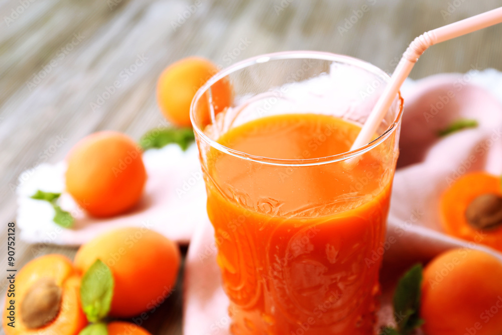 Glass of apricot juice and fresh fruits on table close up Glass of apricot juice and fresh fruits on table close up