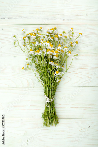 Bouquet of chamomile on green wooden background