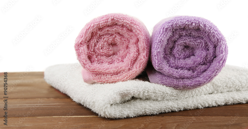 Rolled bath towels on wooden table, closeup Rolled bath towels on wooden table, closeup