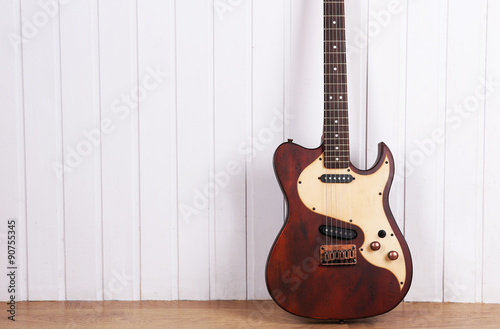 Electric guitar on white wooden wall background