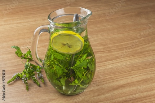 Fresh homemade mint tea. Tempting summer refreshment. Healthy, refreshing drink without sugar. Peppermint tea in a glass jar with lemon. Preparing tea.
